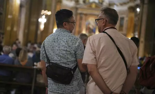 Justin Del Rosario, left, and John Capozzi attend attend a vigil prayer for members of the LGBTQ+ community in the Church of the Gesu' in central Rome, Friday, Sept. 5, 2025. (AP Photo/Andrew Medichini)