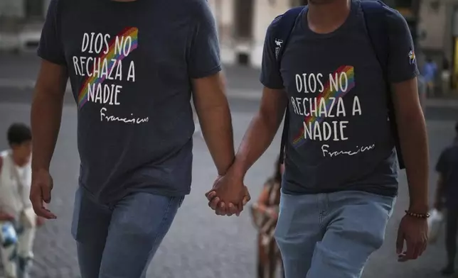 Members of the LGBTQ+ community, who's t-shirts read "God does not reject anyone" in Spanish, arrive to attend a vigil prayer in the Church of the Gesu' in central Rome, Friday, Sept. 5, 2025. (AP Photo/Andrew Medichini)