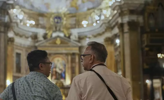 Justin Del Rosario, left, and John Capozzi attend attend a vigil prayer for members of the LGBTQ+ community in the Church of the Gesu' in central Rome, Friday, Sept. 5, 2025. (AP Photo/Andrew Medichini)