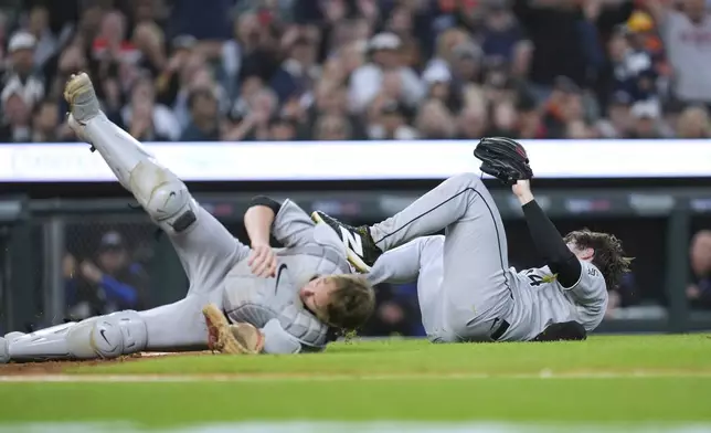 Chicago White Sox catcher Kyle Teel, left, and pitcher Shane Smith, right, collide trying to retrieve a wild pitch against the Detroit Tigers in the fourth inning during a baseball game Friday, Sept. 5, 2025, in Detroit. (AP Photo/Paul Sancya)