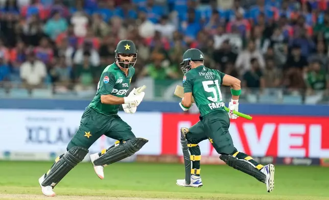 Pakistan's Fakhar Zaman, left, and batting partner Sahibzada Farhan run between the wickets during the Asia Cup Cricket match between Bangladesh and Sri Lanka at Zayed Cricket Stadium in Abu Dhabi , United Arab Emirates, Saturday, Sept. 13, 2025. (AP Photo/Altaf Qadri)