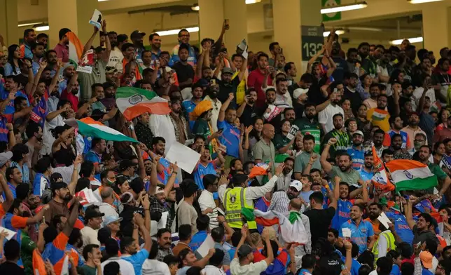 A private security guard pacifies India and Pakistani fans during the Asia Cup cricket final between India and Pakistan at Dubai International Cricket Stadium, United Arab Emirates, Sunday, Sept. 28, 2025. (AP Photo/Altaf Qadri)
