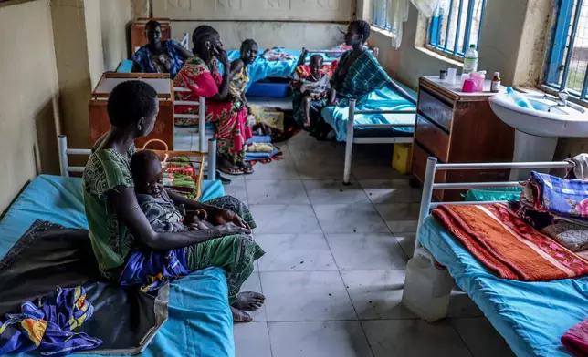 Mothers sit with their children in the malnutrition ward of Bor State Hospital in Bor, South Sudan, Monday, Aug. 18, 2025. (AP Photo/Caitlin Kelly)