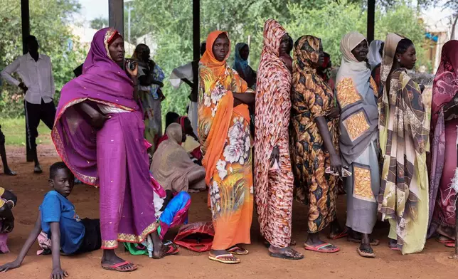 Women wait for cash assistance and dry grain from the U.N. World Food Programme in Gendrassa refugee camp, Maban, South Sudan, Wednesday, Aug. 20, 2025. (AP Photo/Caitlin Kelly)