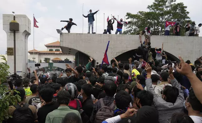 Protesters shout slogans as they gather outside the Parliament building in Kathmandu, Nepal, Monday, Sept. 8, 2025. (AP Photo/Niranjan Shrestha)