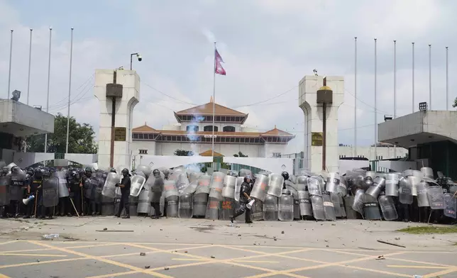 Riot police stand outside the Parliament building as they deal with the protesters in Kathmandu, Nepal, Monday, Sept. 8, 2025. (AP Photo/Niranjan Shrestha)
