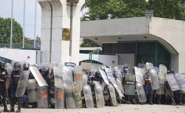 Riot police stand guard outside the Parliament building as they clash with the protesters in Kathmandu, Nepal, Monday, Sept. 8, 2025. (AP Photo/Niranjan Shrestha)