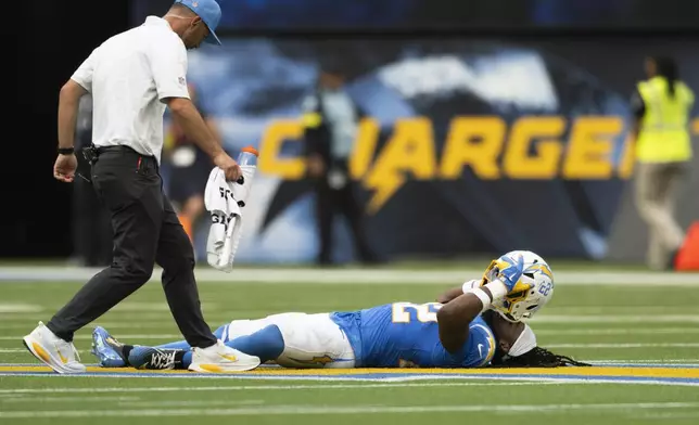 Los Angeles Chargers running back Najee Harris, right, lays on the ground after getting injured during an NFL football game against the Denver Broncos, Sunday, Sept. 21, 2025, in Inglewood, Calif. (AP Photo/Kyusung Gong)