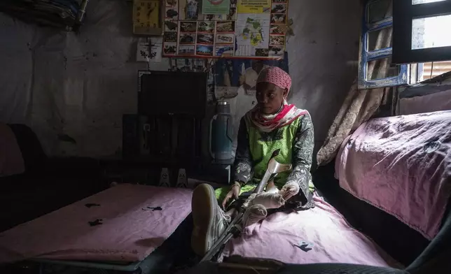 Melissa Amuli, one of many wounded by fighting in the region, sits in her home in Goma, eastern Congo, Friday, Aug. 29, 2025. (AP Photo/Moses Sawasawa)