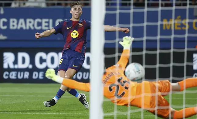 Barcelona's Fermin Lopez scores his side's opening goal during a Spanish La Liga soccer match between FC Barcelona and Valencia at the Johan Cruyff stadium in Barcelona, Spain, Sunday, Sept. 14, 2025. (AP Photo/Joan Monfort)