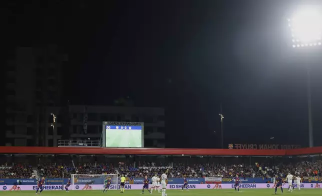 Valencia's Copete, center, controls the ball during a Spanish La Liga soccer match between FC Barcelona and Valencia at the Johan Cruyff stadium in Barcelona, Spain, Sunday, Sept. 14, 2025. (AP Photo/Joan Monfort)