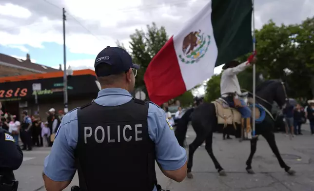Police watch during the 2025 Pilsen Mexican Independence Day parade Saturday, Sept. 6, 2025, in Chicago. (AP Photo/Carolyn Kaster)