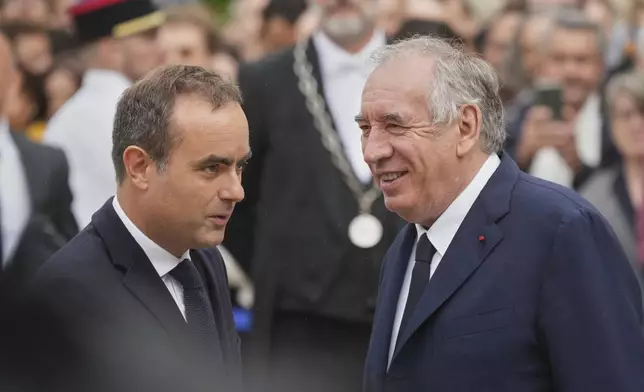 Newly named Prime Minister Sebastien Lecornu, left, is welcomed by outgoing French Prime Minister Francois Bayrou, right, for a handover ceremony at the Prime Minister residence, in Paris, France, Wednesday, Sept. 10, 2025. (AP Photo/Christophe Ena)