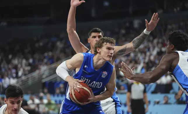 Finland's Lauri Markkanen, centre, tries to shoot while defended by Greece's Kostas Antetokounmpo during the Eurobasket, European Basketball Championship third place match between Greece and Finland at the Riga Arena in Riga, Latvia, Sunday, Sept. 14, 2025. (AP Photo/Sergei Grits)