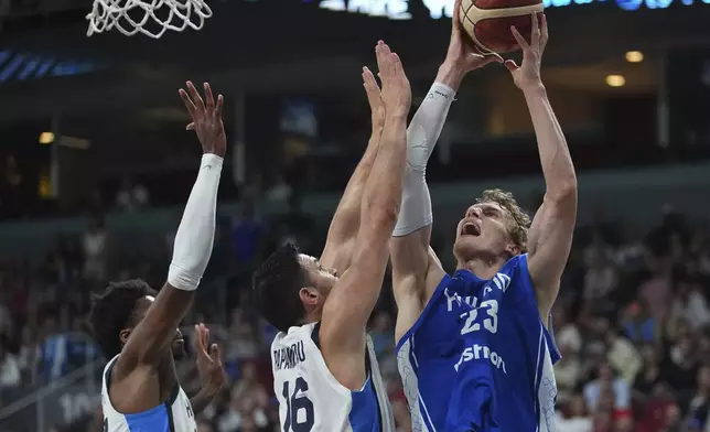 Finland's Lauri Markkanen, right, tries to shoot while defended by Greece's Kostas Papanikolaou during the Eurobasket, European Basketball Championship third place match between Greece and Finland at the Riga Arena in Riga, Latvia, Sunday, Sept. 14, 2025. (AP Photo/Sergei Grits)