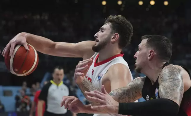 Turkey's Alperen Sengun drives to the basket as Germany's Daniel Theis tries to block him during the Eurobasket, European Basketball Championship final match between Turkey and Germany at the Riga Arena in Riga, Latvia, Sunday, Sept. 14, 2025. (AP Photo/Sergei Grits)