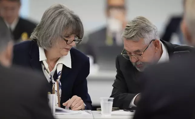 Committee members, Dr. Joseph Hibbeln, right, talks with Vicky Pebsworth, left, during a meeting of the Advisory Committee on Immunization Practices at the CDC on Thursday, Sept. 18, 2025, in Chamblee, Ga. (AP Photo/Brynn Anderson)