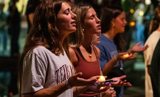 Attendees sing during the worship portion of the vigil for Charlie Kirk at Rudder Plaza on the Texas A&amp;M Campus in College Station, Texas, Thursday, Sept. 11, 2025. (Meredith Seaver/College Station Eagle via AP)