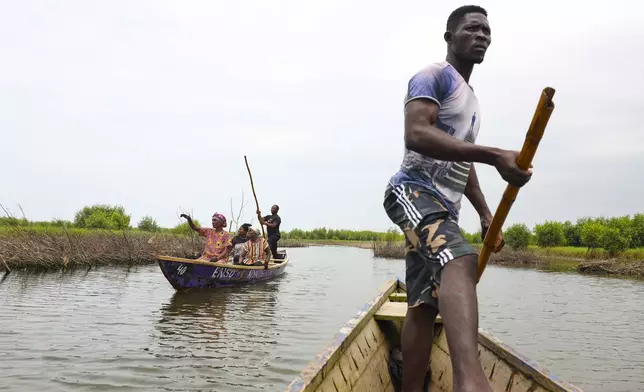 Women ride boats to harvest oysters at Tsokomey, Ghana, Aug. 6, 2025. (AP Photo/Misper Apawu)