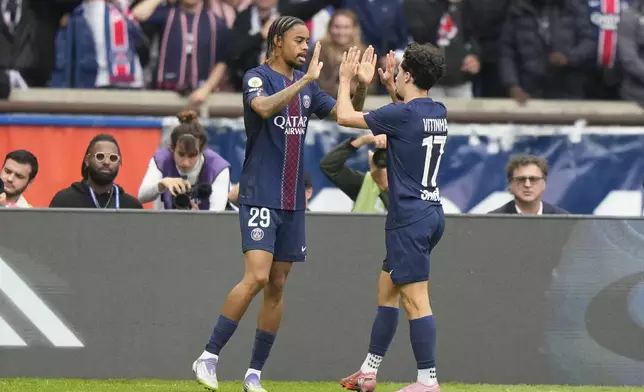 PSG's Bradley Barcola,left, celebrates with PSG's Vitinha, scoring his side's opening goal during the French League One soccer match between Paris Saint-Germain and Le Havre at the Parc des Princes stadium in Paris, Sunday, Sept. 14, 2025. (AP Photo/Michel Euler)