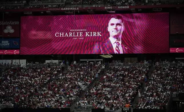A photo of the conservative activist Charlie Kirk is seen on a large screen during a memorial for Kirk, Sunday, Sept. 21, 2025, at State Farm Stadium in Glendale, Ariz. (AP Photo/John Locher)