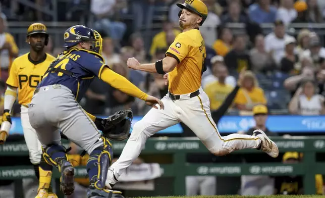 Pittsburgh Pirates' Bryan Reynolds, right, scores as Milwaukee Brewers catcher William Contreras, front left, waits for a late throw during the third inning of a baseball game Friday, Sept. 5, 2025, in Pittsburgh. (AP Photo/Matt Freed)