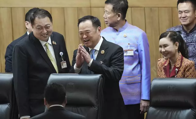 Leader of Bhumjai Thai Party Anutin Charnvirakul, center, talks to lawmakers at Parliament in Bangkok, Thailand, Friday, Sept. 5, 2025. (AP Photo/Sakchai Lalit)