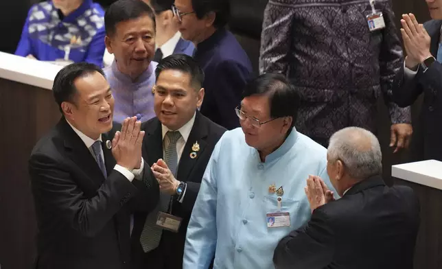 Leader of Bhumjai Thai Party Anutin Charnvirakul, left, talks to lawmakers at Parliament in Bangkok, Thailand, Friday, Sept. 5, 2025. (AP Photo/Sakchai Lalit)
