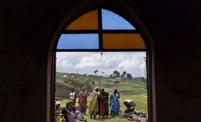 Older residents gather outside a church for their biweekly fellowship which aims to bring seniors together for companionship while providing food and health education, in Rwamucucu, a rural area in western Uganda, Wednesday, Nov. 20, 2024. (AP Photo/David Goldman)