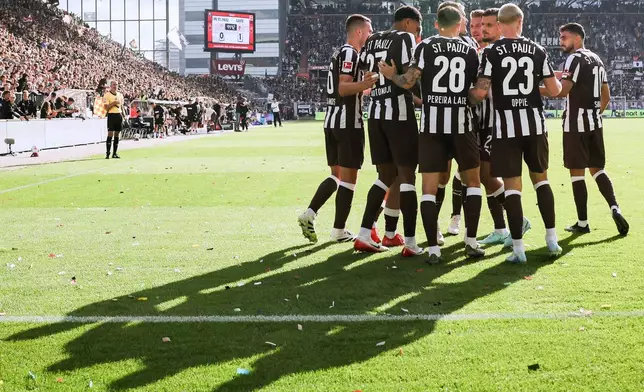 St. Pauli's players celebrate their side's first goal during the German Bundesliga soccer match between 1. FC St. Pauli and FC Augsburg in Hamburg, Germany, Sunday, Sept. 14, 2025. (Christian Charisius/dpa via AP)