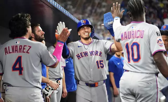 New York Mets' Tyrone Taylor (15) is congratulated after scoring on a walk by Juan Soto during the ninth inning of a baseball game against the Miami Marlins, Saturday, Sept. 27, 2025, in Miami. (AP Photo/Lynne Sladky)