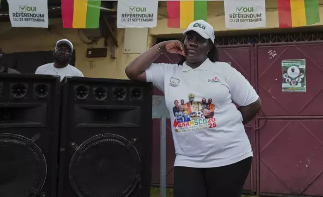 A supporter stands next to speakers during a community rally ahead of the constitutional referendum in Conakry, Guinea, Monday, Sept. 15, 2025. (AP Photo/Misper Apawu)
