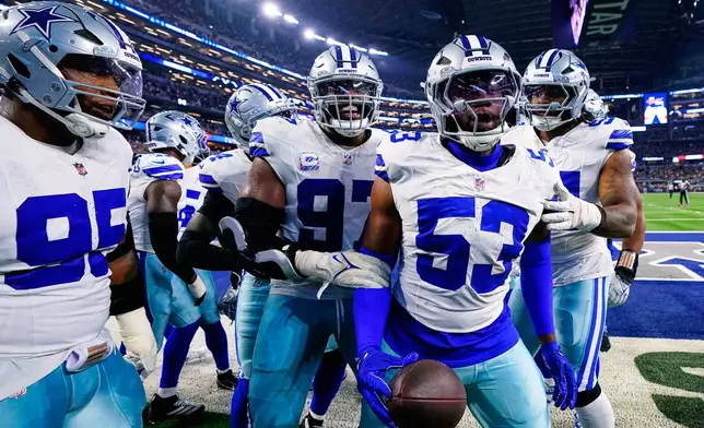 Dallas Cowboys defensive end James Houston (53), Osa Odighizuwa, and Kenny Clark (95) celebrate with others after Houston recovered a Green Bay Packers fumble in the first half of an NFL football game Sunday, Sept. 28, 2025, in Arlington, Texas. (AP Photo/Jeffrey McWhorter)