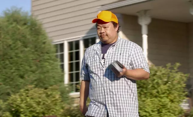 Xp Lee, Democratic candidate for Minnesota house district 34B, knocks on doors during campaigning in Brooklyn Park, Minn., Thursday, Sept. 11, 2025. (AP Photo/Mark Vancleave)