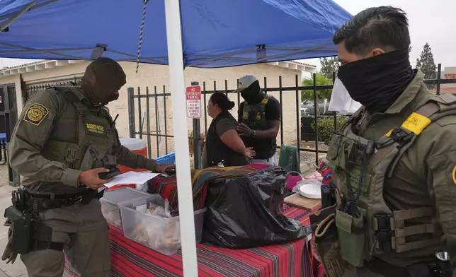 A woman is detained by U.S. Border Patrol agents outside a Home Depot Friday, Aug. 15, 2025, in Los Angeles. (AP Photo/Gregory Bull, File)
