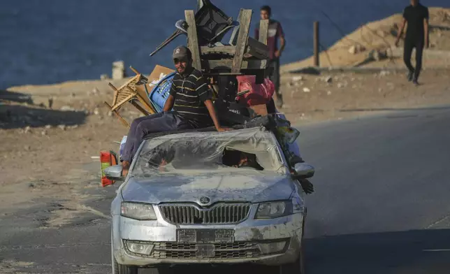 Displaced Palestinians fleeing northern Gaza carry their belongings in a car along the coastal road toward southern Gaza, Friday, Sept. 5, 2025. (AP Photo/Jehad Alshrafi)