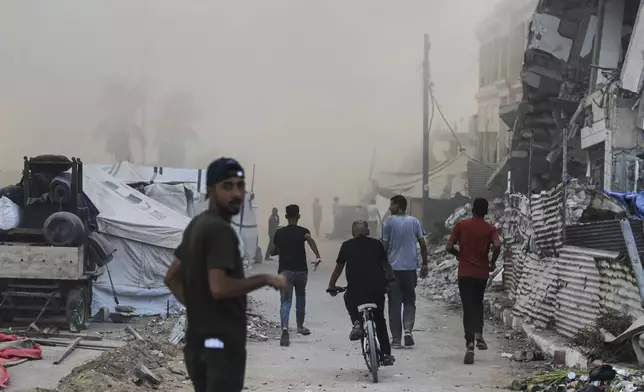 Palestinians rush to the site of an Israeli army airstrike on a high-rise building in Gaza City, Friday, Sept. 5, 2025, after the Israeli army issued a prior warning. (AP Photo/Yousef Al Zanoun)