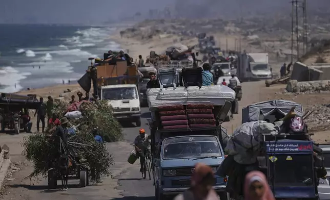 Displaced Palestinians fleeing northern Gaza carry their belongings along the coastal road toward southern Gaza, Tuesday, Sept. 9, 2025, after the Israeli army issued evacuation orders from Gaza City. (AP Photo/Jehad Alshrafi)