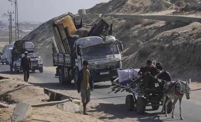 Displaced Palestinians fleeing northern Gaza carry their belongings along the coastal road toward southern Gaza, Tuesday, Sept. 9, 2025, after the Israeli army issued evacuation orders from Gaza City. (AP Photo/Jehad Alshrafi)