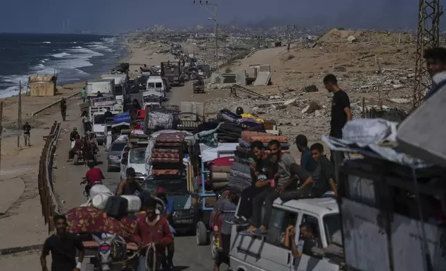 Displaced Palestinians fleeing northern Gaza carry their belongings along the coastal road toward southern Gaza, Tuesday, Sept. 9, 2025, after the Israeli army issued evacuation orders from Gaza City. (AP Photo/Jehad Alshrafi)