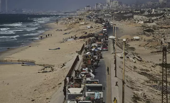 Displaced Palestinians fleeing northern Gaza carry their belongings along the coastal road toward southern Gaza, Tuesday, Sept. 9, 2025, after the Israeli army issued evacuation orders from Gaza City. (AP Photo/Jehad Alshrafi)