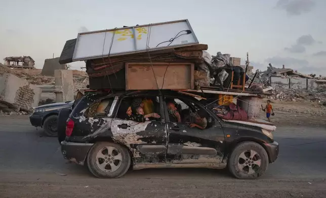 Displaced Palestinians fleeing northern Gaza carry their belongings along the coastal road toward southern Gaza ,Sunday, Sept. 7, 2025. (AP Photo/Jehad Alshrafi)