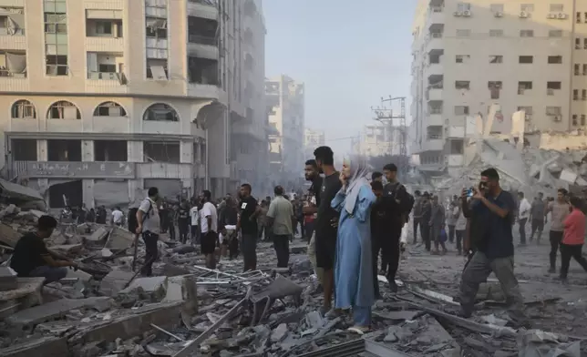 Palestinians inspect the damage after an Israeli army strike on a building in Gaza City, Sunday, Sept. 7, 2025, after the Israeli army issued a prior warning. (AP Photo/Yousef Al Zanoun)