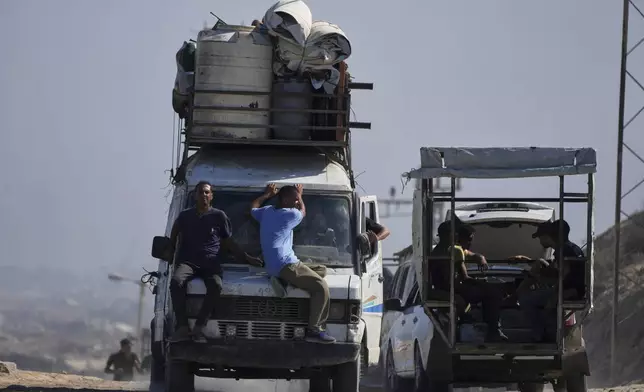 Displaced Palestinians fleeing northern Gaza carry their belongings along the coastal road toward southern Gaza, Tuesday, Sept. 9, 2025, after the Israeli army issued evacuation orders from Gaza City. (AP Photo/Jehad Alshrafi)