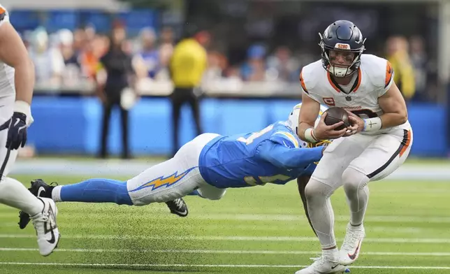 Denver Broncos quarterback Bo Nix (10) evades the tackle from Los Angeles Chargers linebacker Kyle Kennard (54) during the second half of an NFL football game Sunday, Sept. 21, 2025, in Inglewood, Calif. (AP Photo/Gregory Bull)
