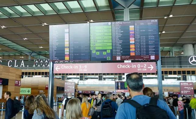 People at BER airport as a cyber attack has caused delays, in Berlin, Germany, Saturday, Sept. 20, 2025. (Carsten Koall/dpa via AP)