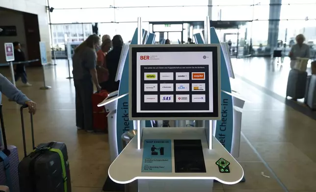 People at BER airport as a cyber attack has caused delays, in Berlin, Germany, Saturday, Sept. 20, 2025. (Carsten Koall/dpa via AP)
