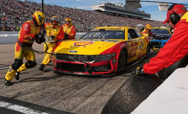 The crew of Joey Logano changes tires during a pit stop during a NASCAR Cup Series race at New Hampshire Motor Speedway, Sunday, Sept. 21, 2025, in Loudon, N.H. (AP Photo/Charles Krupa)