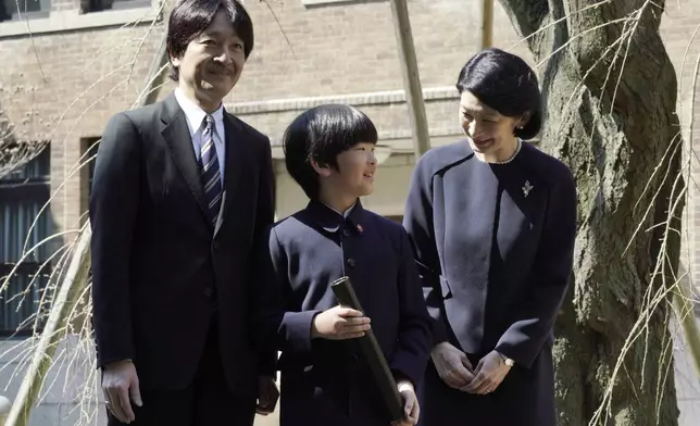 FILE - Japan's Prince Hisahito, center, accompanied by his parents Prince Akishino and Princess Kiko pose for media after his graduation ceremony of a primary school affiliated with Ochanomizu University in Tokyo on March 15, 2019. (AP Photo/Eugene Hoshiko, Pool, File)