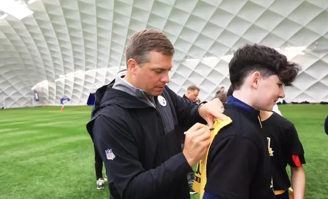 Pittsburgh Steelers' Dan Rooney signs autographs at the NFL Flag Football in Belfast, Northern Ireland, Thursday, Sept 25, 2025. (Peter Morrison/AP Content Services for the NFL)